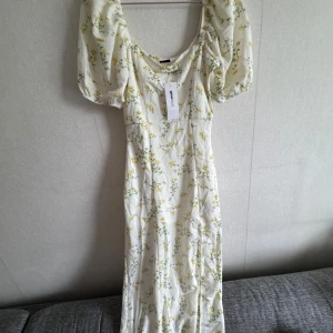 Blommig långklänning från Ginatricot  - Aldrig använd med tags kvad. Köpt för 399 kr.
