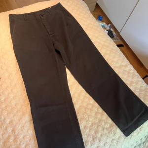 Marinblåa workpants från HOPE Stockholm - Snygga marinblåa workpants från HOPE Stockholm i klassisk rak modell. Byxorna har bälteshällor, snedställda fickor fram och en bakficka med lock och knapp. Tillverkade i bomull för en skön och stilren känsla.