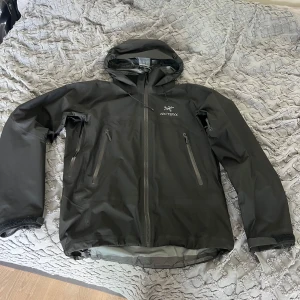 Svart Arc'teryx Beta AR regnjacka - Säljer nu min fantastiska Arc’teryx jacka som har använts i tre säsonger. Modellen heter Beta AR (storlek M) och är en hybrid mellan extremsport och vardaglig användning. köpte den från friluftsboden och bör ha ett kvitto någonstans. Denna skaljacka kan troligtvis vara din sista jacka pga Arc’teryx livstids garanti där ni kan fixa nästan allt gratis!  MVH Gordon