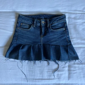 Jeanskjol med volang  - Säljer en blå jeanskjol med volang nertill och rå, fransig kant. Säljer för att den har blivit för liten för mig.