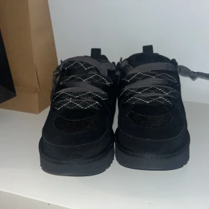 UGG Lowmel lows  - Snygga svarta sneakers från UGG med robust platåsula. detaljer i mocka och mesh samt rund tå. Perfekta för dig som vill ha ett par sköna skor till vintern. Skick 10/10 aldrig använts