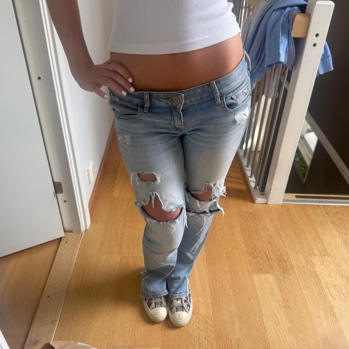 Ljusblå slitna lågmidjade jeans