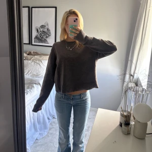 Mörkbrun stickad tröj - Mysig mörkbrun stickad tröja med croppad passform och långa ärmar. 