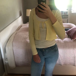 Ljusgul kofta med knyt - Supersöt ljusgul kofta med långa ärmar och knyt framtill. Koftan har en mjuk känsla som passar perfekt till jeans eller kjol. Enkel och fräsch färg som lyfter vilken outfit som helst. Perfekt till sommaren, hösten o våren! 