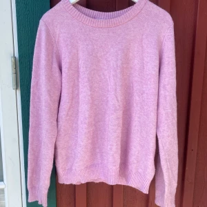 Ljusrosa stickad tröja från Vila - Supermjuk ljusrosa stickad tröja från Vila i storlek L. Tröjan har rund halsringning, ribbade muddar och är långärmad. En liten tråd är dragen men knappt märkbar (se bild).