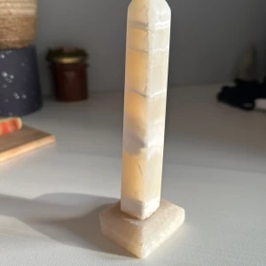 Kristallspets - Säljer en kristallspets, vet inte kristallsorten men den är gul i solljus och beige annars. Den lutar lite som man kan se i bilderna.