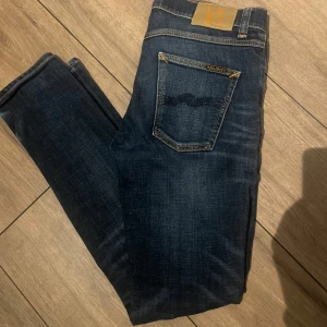 Mörkblå jeansbyxor från Nudie Jeans - Säljer dessa riktigt fetta nudie jeansen, bra skick men täcken på användning. Bara och skriva för fler bilder🤩 Priset är inte hugget i sten. 