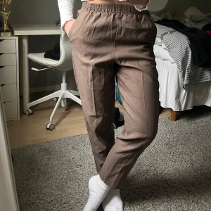 Bruna kostymbyxor med resårmidja - Bruna kostymbyxor med elastisk midja och raka ben. Knappt använda🤎Köpt på en thrift store