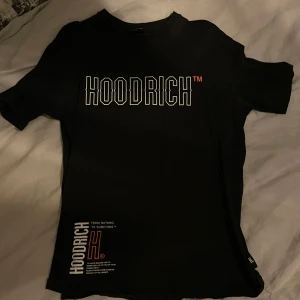 Svart t-shirt från Hoodrich med tryck - Svart t-shirt från Hoodrich med stort vitt och orange tryck på bröstet och ryggen. Snygga detaljer med texten 'From nothing to something' och grafiska element. Klassisk passform och rund halsringning.