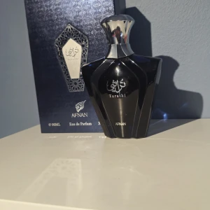 Afnan Turathi Eau de Parfum 90ml - Exklusiv parfym från Afnan, Turathi, i en elegant svart och silverfärgad flaska med geometrisk design. Flaskan rymmer 90 ml Eau de Parfum och levereras i en lyxig presentask. Perfekt för dig som vill ha en unik och sofistikerad doftupplevelse.