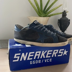 Golden Goose skor  - Mörkblåa och svarta golden goose skor i superstar modellen. Storlek 45(innesula 28,5cm) Perfekta skor inför sommaren. Nypris cirka 6000kr || mitt pris 1699kr! Lite slitna i hälen men annars är de i jättebra skick. Box ingår och kvitto finns
