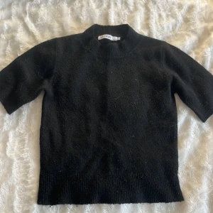 Svart stickad topp från BY SWAN - Svart stickad topp från BY SWAN Paris köpt på missäy, med korta ärmar och högre ribbad hals. Modellen är rak och något boxig, med ribbade muddar vid ärmslut och nederkant. Använde ganska mycket men den är i bra skick. Kan mötas upp i Kungälv eller Göteborg💕🫶🏼