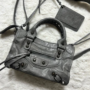 Handväska grå  - Grå handväska i nyskick. Spegel/plånbok medföljer.  Mått ca 24x14. Säljer även fler likande väskor i olika färger och storlekar. Köp sker via köp nu, jag postar inom 24h. Kvar tills markerad såld 