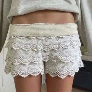 Beiga spetsshorts  - Superfina beiga spetshorts med virkade volanger och elastisk resår i midjan. Perfekta för sommardagar eller festival.