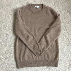 Beige merinoulltröja  - Säljer en supermjuk och stilren beige tröja från Garde Grisch i 100% merinoull. Tröjan har rund halsringning, långa ärmar och ribbade muddar vid ärmslut och nederkant. Perfekt för lager-på-lager under kyliga dagar.