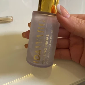 Ida Warg Tanning Drops - Säljer en flaska Ida Warg Tanning Drops med guldig kork och frostat glas. Perfekt för att blanda i din dagkräm för en solkysst look. Produkten är vegansk och parfymfri.