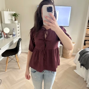 Vinröd blus med knytningar  - Vinröd blus med knyt framtill som aldrig är använd. Storlek XS. Jätte fin och bra till sommaren 