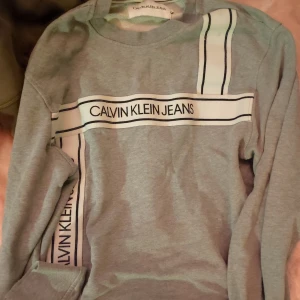 Svarta jeans från Calvin Klein plus tröja Calvin Klein  - Säljer ett par svarta jeans från Calvin Klein med klassisk femficksdesign och diskret CK-logga på bakfickan. Jeansen har normal passform och raka ben, perfekta till vardags. Materialet är mjukt och följsamt. Storlek S 200 kr säljes tillsammans 