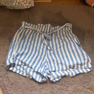 Blårandiga sommar shorts - De här blå och vit randiga barn shortsen från Kappahl är perfekta till sommarn! De är mjuka och sköna och skonsamt använda. Lite skrynkliga i bilden men inget svårt att fixa.
