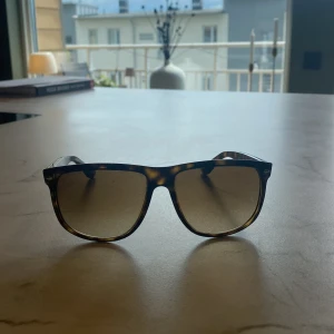  Ray-Ban Boyfriends - Snygga solglasögon från Ray-Ban med fyrkantig form och klassiskt sköldpaddsmönster. Glasen är bruna och bågarna har en stilren design som passar till många tillfällen.
