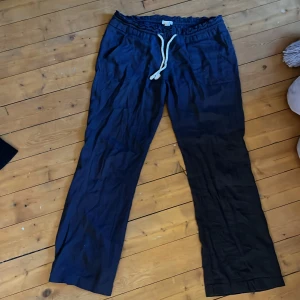 Marinblå linnebyxor från Roxy med snörning - Säljer ett par marinblå linnebyxor från Roxy. De finns en liten skada vid banden där fram men de ör inget som syns när byxorna är på. Dem ör väldigt sparsammt andvönda. Byxorna har fickor både fram och bak och är perfekta för en avslappnad stil. Superlätta och sköna att bära.