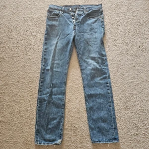 Levis 501 blå jeans med raka ben - Klassiska blå Levis 501 jeans med raka ben och knäppning framtill.