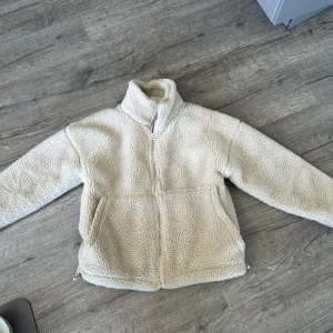 Vit teddyjacka från Carin Wester - Mysig beige teddyjacka från Carin Wester. Säljer pgu att den inte används. Har använts väldigt sparsamt under förra hösten så den är i väldigt fint skick. 