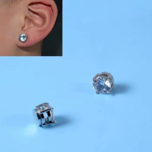 Silverfärgade örhängen med klar sten (magnet) - Säljer ett par stilrena örhängen i silverfärg med rund, klar sten. Kommer i en praktisk liten ask. Perfekta för dig som gillar enkel men snygg design.