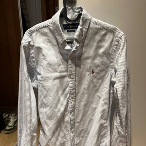 Ralph Lauren Oxford skjorta vit/blå randig - Klassisk blå- och vitrandig skjorta i Oxford modell  från Ralph Lauren i slim fit. En tidlös skjorta som passar till bokstavligen allt. Utmärkt skick. Hojta vid fler frågor 