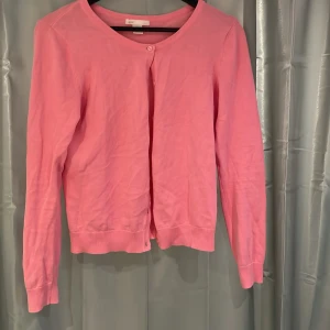 Rosa kofta  - Säljer en söt rosa kofta från H&M Basic. Koftan har rund halsringning, långa ärmar och knäppning framtill med små knappar. 