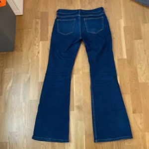 Mörkblå low waist flare jeans från hm🙌 - Säljer ett par mörkblå low waist flare jeans från hm i storlek 38. Jeansen har fejk fickor fram, och fullt fungerande fickor bak. Använda ett par gånger men är ändå i bra skick. De är också stretchiga och bra i längden för de långa. 💗