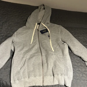 Grå hoodie från Polo Ralph Lauren - Helt ny zip hoodie ifrån Ralph Lauren. Säljer den pågrund av att den är för stor för mig. Priset är inte fast det kan diskuteras om. Hör gärna av dig vid frågor