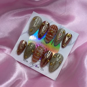 Zodia (M);Medium Almond - Snygga gelé press-on naglar i medium mandelform med mix av beige, brunt och metallic roséguld. Dekorerade med guldiga pärlor och detaljer som stjärnor, månar och linjer. Setet innehåller storlek M: 16 mm, 12 mm, 12,5 mm, 11,5 mm, 10 mm , perfekta för att ge en unik look.
