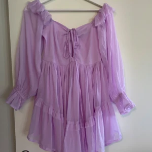 Ny Ljuslila Asos volangklänning med snörning - Aldrig använd. Storleken passar XS eller S. Kan justeras med snörning. 