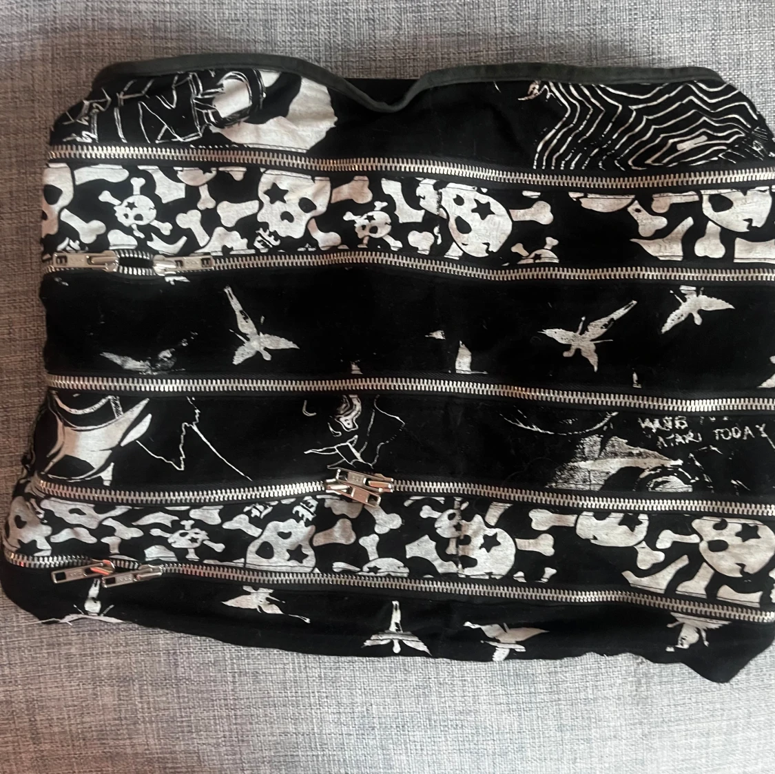 Svart miniskirt med dödskallemönster och dragkedjor