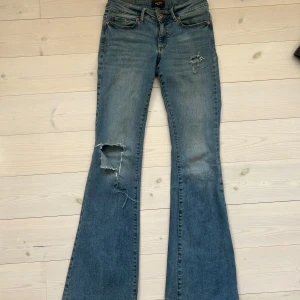 Blå bootcut jeans från Vero Moda - Bootcut jeans från vero Moda i strl 29/32, passar bra på mig som är 170 i längden 🥰 ( se defekt på sista bilden)