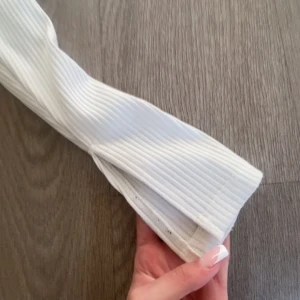 Vit ribbad långärmad topp Gina Tricot - Säljer en vit ribbad långärmad topp från Gina Tricot. Tröjan har en tight passform, rund halsringning och är tillverkad i stretchig bomullsmix. 