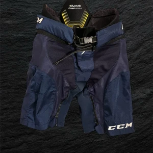 CCM Tacks 7092 hockeyshorts junior - Mörkblå hockeyshorts från CCM, modell Tacks 7092 Girdle. Shortsen har vadderat skydd, snörning och bälte i midjan samt dragkedjor på benen. Tillverkade i slitstark material och designade för att ge bra rörelsefrihet på isen.