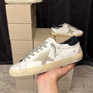 Golden goose skor - Sprillans nya golden goose skor i storlek 40. Skorna är helt nya med vattenskadad box, dustbag och äkthetsintyg. Priset är nedsatt från 3800 till 3500 på grund av den skadade boxen. 14 dagar returrätt och klarna - köp nu betala senare erbjuds på hemsidan - Manercloset.com