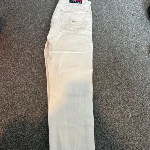 Vita jeans från Tommy Hilfiger - Snygga vita jeans från Tommy Hilfiger med klassisk rak passform och diskret logga på bakfickan. Byxorna har normal midja och är tillverkade i bomull för en skön känsla. Perfekta för en clean och fräsch look.