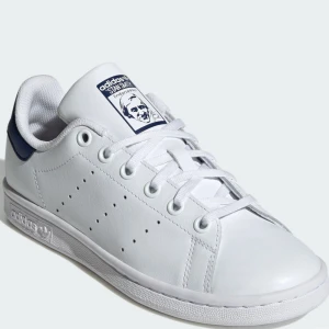 Adidas Stan Smith vita sneakers - Säljer dessa vita sneakers med marinblå detalj som endast använts 1 gång!! Säljer då de var för små och hann inte skicka tillbaka💗Storlek: 37 1/3