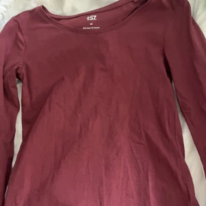 Mörkröd långärmad tröja 157 XS - En basic mörkröd långärmad tröja från 157 i storlek XS. Tröjan är i mjuk bomull med lite stretch för en skön passform. Perfekt att styla med jeans eller kjol för en enkel och snygg look.