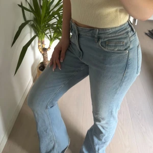  bootcut jeans - Säljer ett par ljusblå bootcut jeans med snygga strassdetaljer längst ner på benen. Jeansen är från Gina tricot 🌸