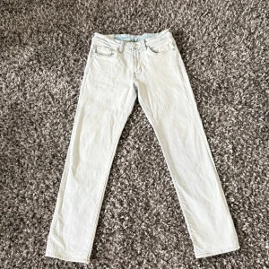 Ljusblåa raka jeans - Snygga ljusblåa jeans med klassisk femficksdesign och raka ben. Jeansen har normal midja och är tillverkade i ett mjukt bomullstyg. Perfekta för dig som vill ha en clean och fräsch look.