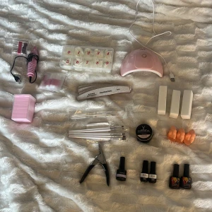 Nagelkit - Säljer ett komplett nagelkit. Det kommer med en rosa elfil med 6 olika huvuden, USB kontakt. Tippar i olika storlekar, alla kvar. Rosa UV lampa med USB kontakt. 10st nagellim. 200st nagelkuddar. 5st vanliga filar (professional) 80/80. 3st vita nagelbuffertblock. 5st olika penslar. 3st design penslar. Gelé från YOKEFELLOW Hard Gel UV & LED CURED YMH03. 3st test fingrar. En nagelklippare med magneter till. Primer från Kaymay, Base coat, Top coat från Full beauty. 2st helt vanliga vita nagellack. 