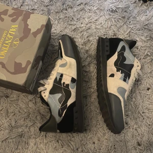 Valentino rockrunner  - Säljer ett par Valentino Rockrunner sneakers med grå, svart och beige camouflage-mönster.