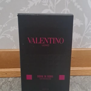 Valentino Uomo Born In Roma EdP - Stilren parfym från Valentino, Born In Roma Uomo Extradoze. Flaskan är svart med nitar och har en lyxig, matt finish. Märkets logga syns i rosa på både flaska och kartong. Perfekt för dig som gillar exklusiva och moderna dofter.