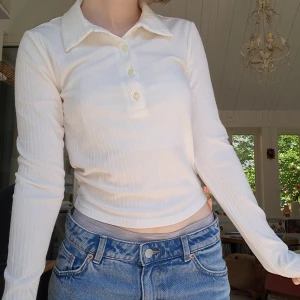 Långärmad ribbad tröja med krage - Vit långärmad ribbad tröja med krage från gina tricot, enkel men fin. Tight fit. Passar till skoloutfiten, bra för layering med tröja över när det är kallt. Lite nopprig, se sista bild .