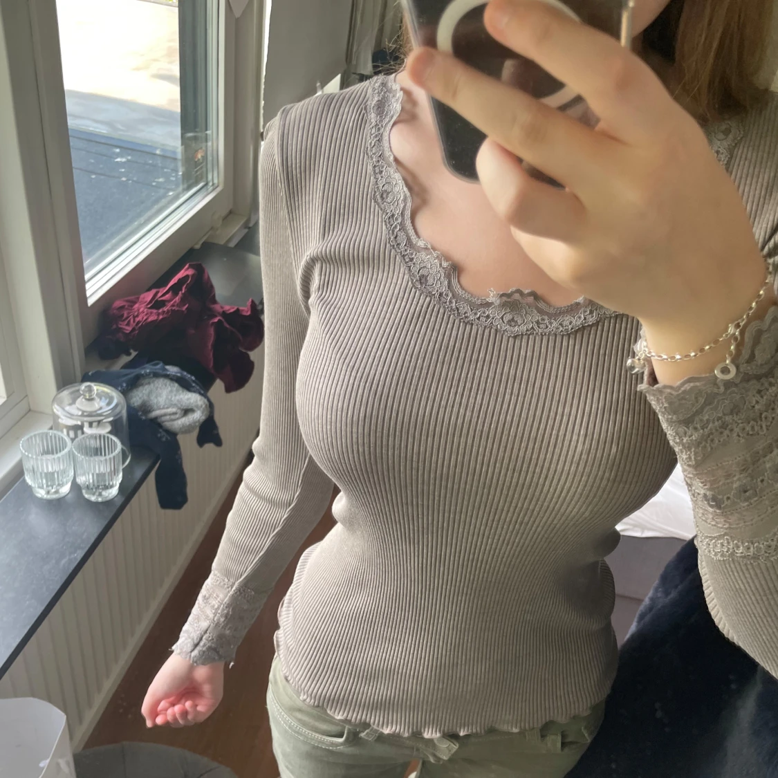 GrĂ„ ribbad topp med spetsdetaljerđ