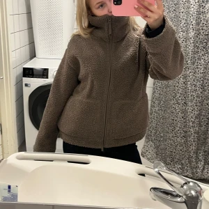Brun teddyjacka - Mysig brun teddyjacka med dragkedja och hög krage. Perfekt för kyliga dagar. Jackan har långa ärmar och en avslappnad passform. Storlek m men passar mig superbra som brukar ha xs-s
